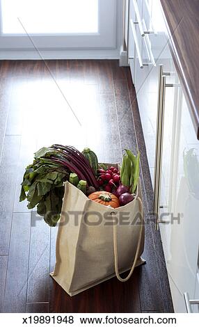 Eco Friendly Shopping Bag Filled With Vegetables On Kitchen Floor