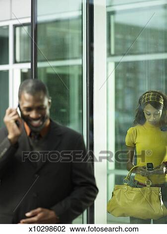Businessman Talking On Mobile Outside Building Young Woman