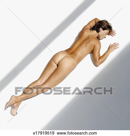 High Angle View Of A Naked Young Woman Lying On The Floor Stock