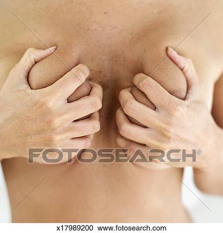 450px x 470px - Close-up of a nude young woman's hands squeezing her breasts Stock Image