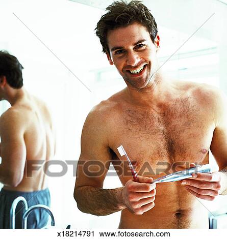 Portrait Of A Young Man Holding A Tooth Brush And A Tube Of