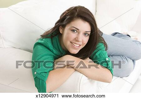 Beautiful Teenage Girl Laying On Couch Green Shirt Stock Image