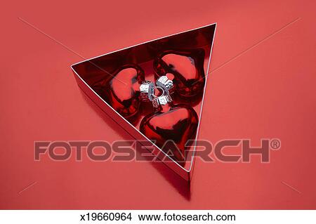 stock photo of three heart shaped ornaments in a triangular box