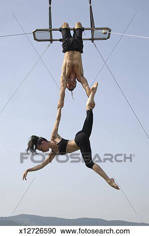 Stock Photography of Male and female acrobats perform high on trapeze ...