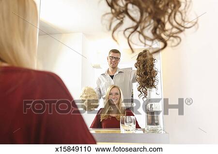 A Hairdresser Showing A Client Wigs For New Style Stock Image