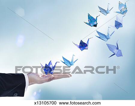 Origami Cranes Flying Away From Mans Hand Stock Image