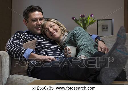Couple Cuddle Up On Sofa Stock Photography X12550735 Fotosearch