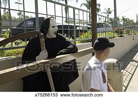 Grim Reaper And Man Waiting At Bus Stop Stock Image - 