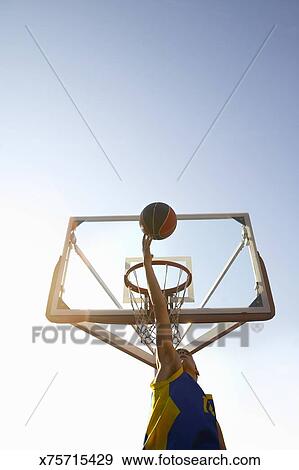 Low Angle Shot Of A Boy Playing Basketball Stock Photo X75715429