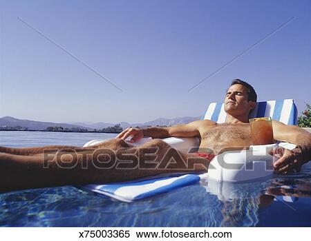 Man Relaxing In Floating Chair In Pool Surface View Stock