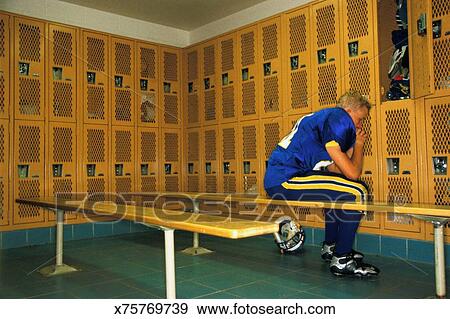 Teenage Football Player 16 18 Sitting On Bench In Locker Room