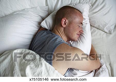 Man Sleeping And Hugging Pillow Smiling Stock Photograph