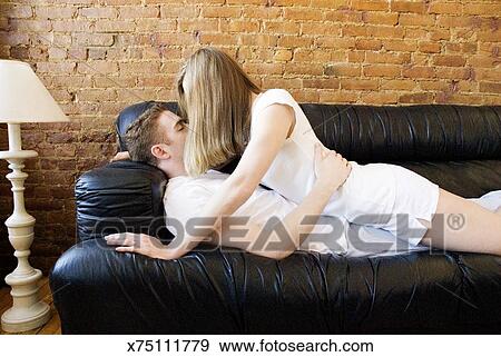 Young Couple Making Out On Sofa Side View Stock Photo X75111779