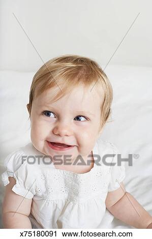 Baby Girl With Blonde Hair And Blue Eyes Smiling Stock Image