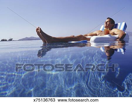 Man Relaxing In Floating Chair In Pool Surface View Stock Image
