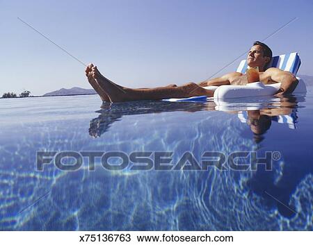 Man Relaxing In Floating Chair In Pool Surface View Stock Image