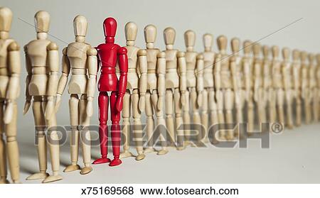 Red Mannequin Stands In A Long Line Of Wooden Ones Stock Photo