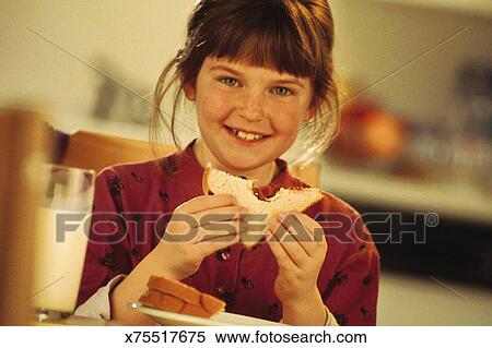 Girl Eating A Peanut Butter And Jelly Sandwich Stock Photography