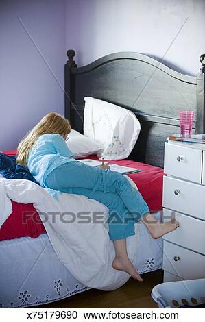 12 Year Old Girl Doing Homework On Her Bed Stock Image