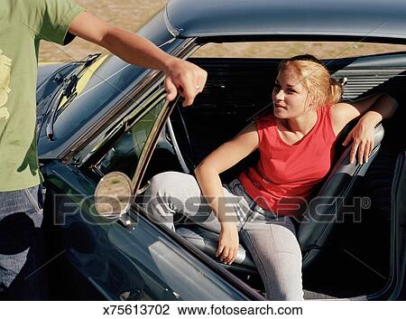 Young Woman Sitting In Car Man Holding Door Open Stock Image