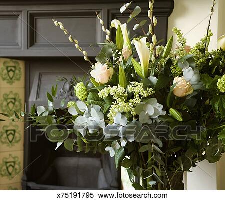 Arrangement Of Calla Lilies And Roses Near Fireplace Mantel Stock