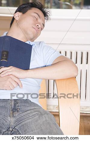 Young Man Sleeping In Chair With Book On Chest Picture X75050604