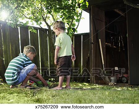 Two Boys In Backyard Burying Pet Stock Photo X75267209 Fotosearch