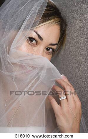 Bride holding veil over face View Large Photo Image Stock Image - Bride holding veil over face. Fotosearch