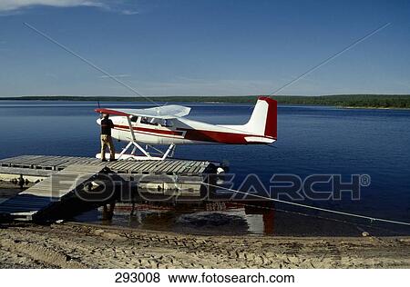 Man standing on jetty next to seaplane View Large Photo Image Stock Photo - Man standing on jetty next to seaplane. Fotosearch