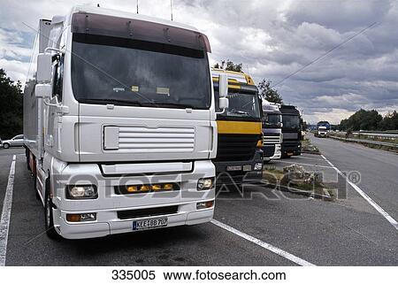 Stock Photography - Row of semi trucks parked at rest stop. Fotosearch
