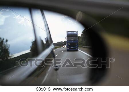 Semi truck traveling on highway as seen in rear-view mirror View Large Photo Image Stock Image - Semi truck traveling on highway as seen in rear-view mirror. Fotosearch