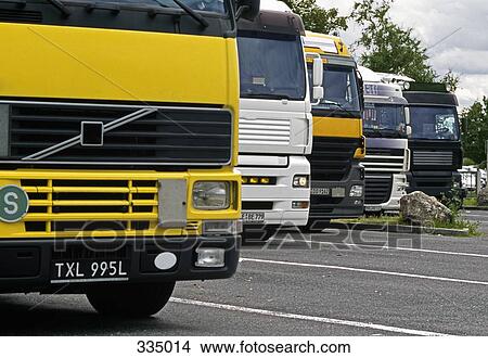 Semi trucks parked side by side at rest stop View Large Photo Image Picture - Semi trucks parked side by side at rest stop. Fotosearch