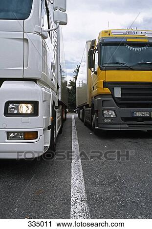 Semi trucks parked side by side at rest stop View Large Photo Image Stock Image - Semi trucks parked side by side at rest stop. Fotosearch