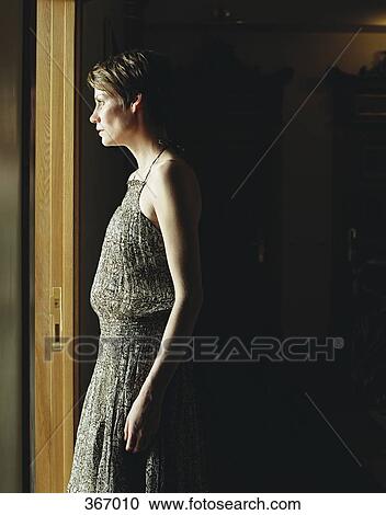 Side view of woman in a dark room, illuminated by sunlight View Large Photo Image Stock Image - Side view of woman in a dark room, illuminated by sunlight. Fotosearch