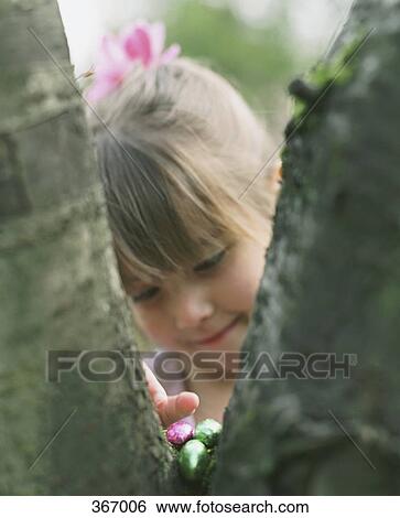 Young girl doing Easter egg hunt View Large Photo Image Stock Photograph - Young girl doing Easter egg hunt. Fotosearch