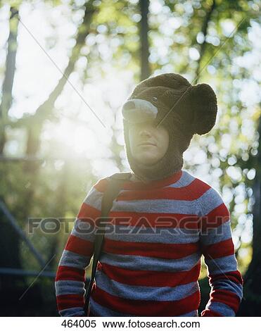 Stock Photography - Young man standing in a forest wearing part of a bear costume. Fotosearch