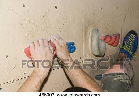 Stock Photo - Detail of a man indoor rock climbing. Fotosearch