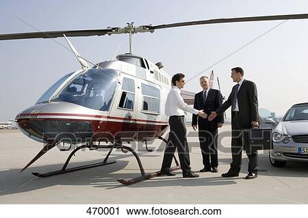 Businessmen shaking hands by a helicopter View Large Photo Image Stock Image - Businessmen shaking hands by a helicopter. Fotosearch