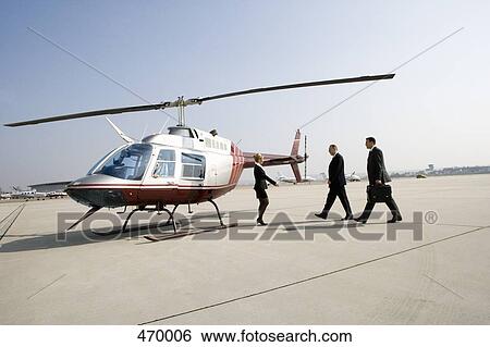 Businesswoman greeting two businessman by a helicopter View Large Photo Image Stock Photograph - Businesswoman greeting two businessman by a helicopter. Fotosearch