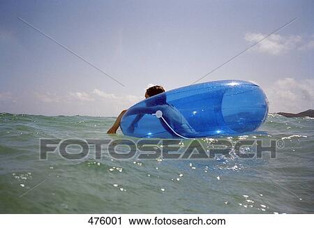 A woman floating on an inner tube in the sea View Large Photo Image Stock Image - A woman floating on an inner tube in the sea. Fotosearch