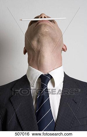 A businessman balancing a pencil between his nose and his lips View Large Photo Image Stock Photograph - A businessman balancing a pencil between his nose and his lips. Fotosearch