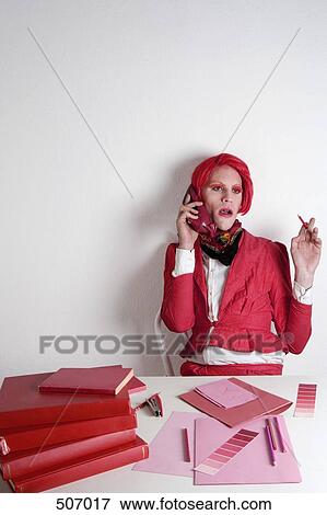 Stock Photo - Drag queen sitting at a desk. Fotosearch