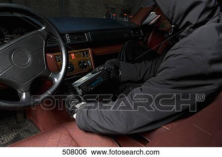 A thief stealing a car stereo View Large Photo Image Stock Photograph - A thief stealing a car stereo. Fotosearch