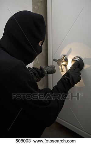 Stock Image - A thief unlocking a combination safe. Fotosearch