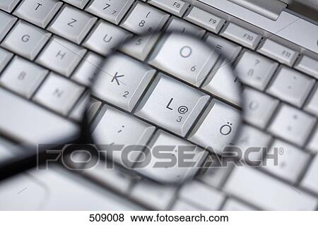 A magnifying glass over a laptop keyboard View Large Photo Image Stock Photo - A magnifying glass over a laptop keyboard. Fotosearch
