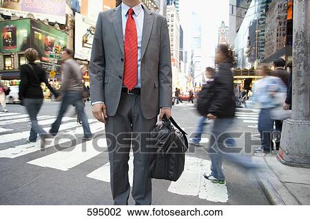 A businessman standing by a pedestrian crossing View Large Photo Image Stock Image - A businessman standing by a pedestrian crossing. Fotosearch