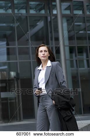 A businesswoman standing outside an office building View Large Photo Image Stock Image - A businesswoman standing outside an office building. Fotosearch