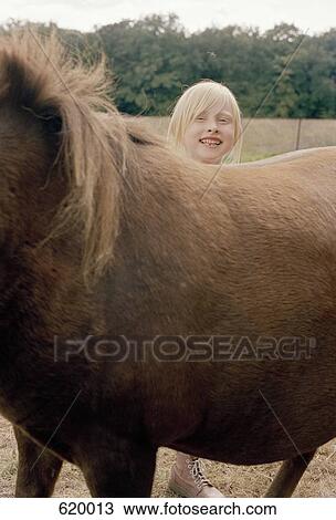 A girl standing behind a horse View Large Photo Image Stock Image - A girl standing behind a horse. Fotosearch