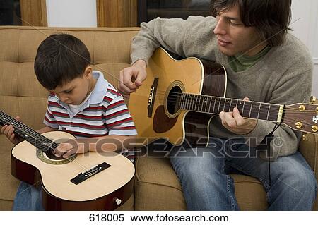 A man and boy playing guitar together View Large Photo Image Stock Photography - A man and boy playing guitar together. Fotosearch