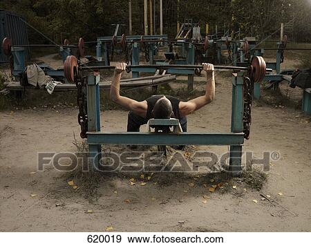 A man lifting weights outside View Large Photo Image Stock Photo - A man lifting weights outside. Fotosearch